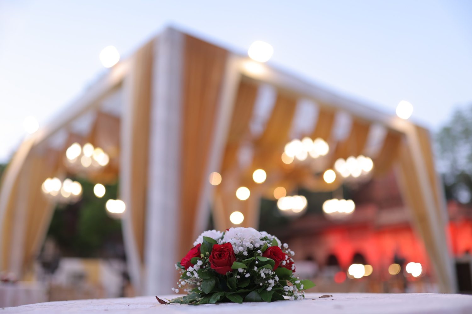 A festive bouquet with warm string lights at an evening celebration