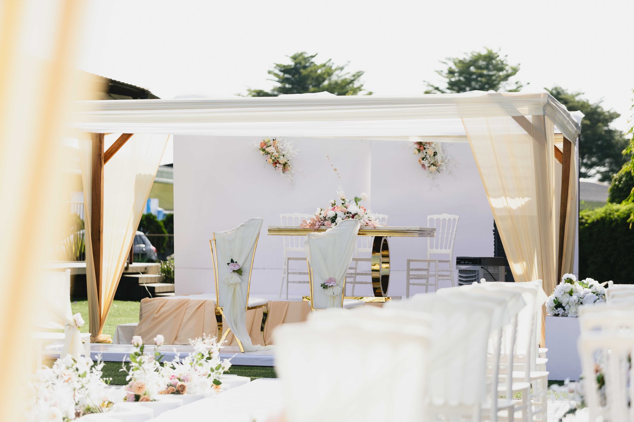 An elegant outdoor reception set with florals and gold chairs